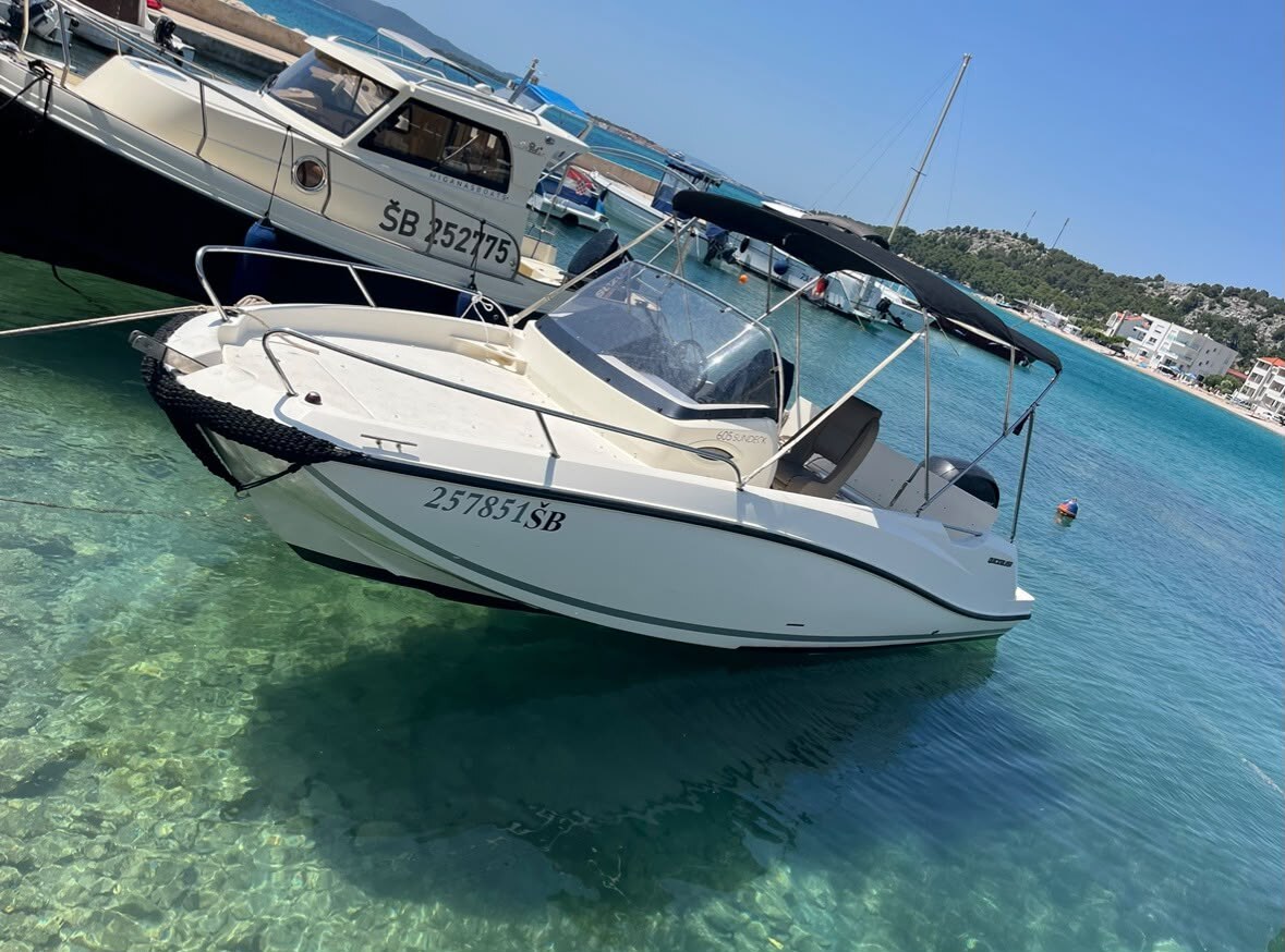 Quicksilver 605 anchored in a turquoise cove near Šibenik